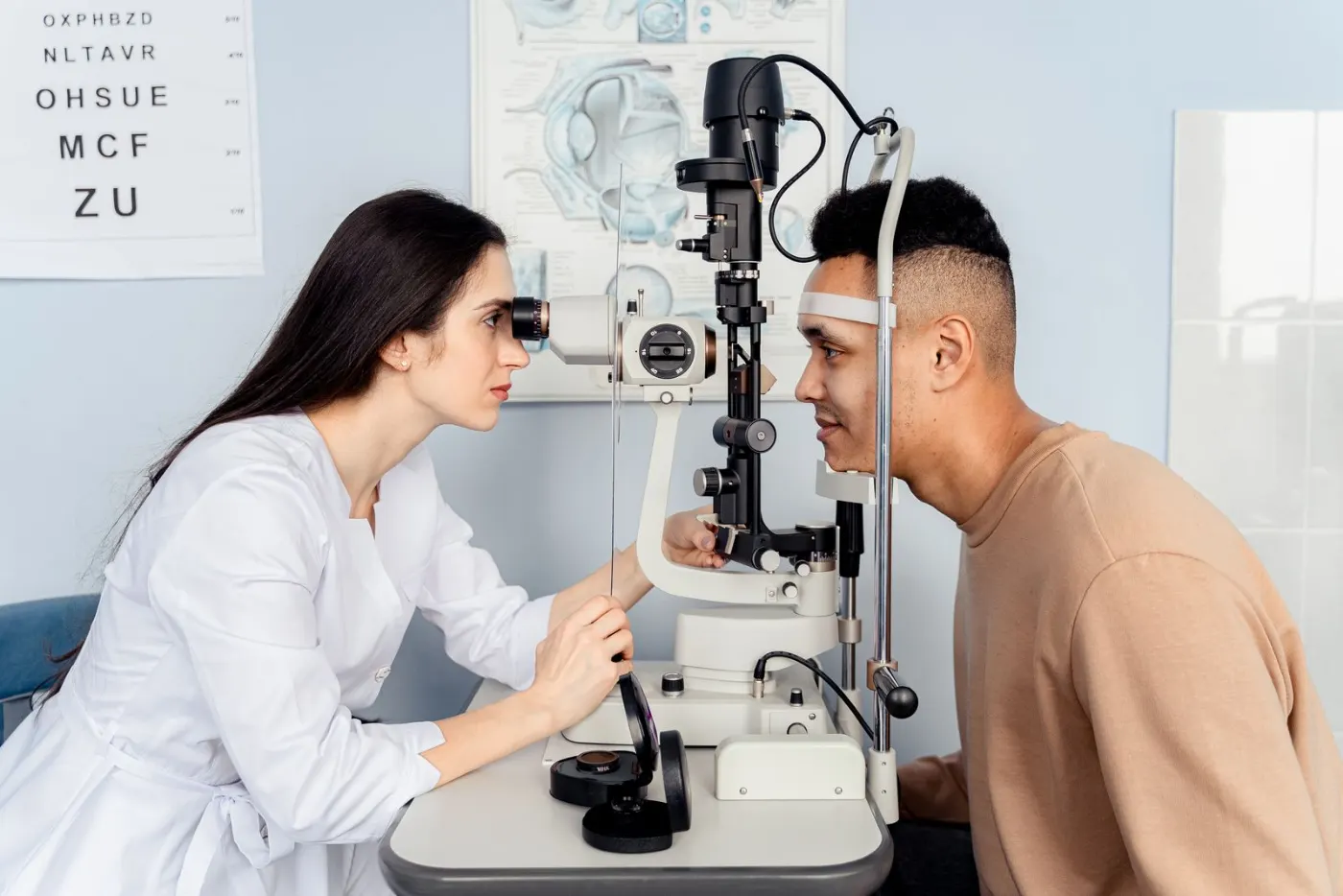 An eye doctor examining a patient at a slit lamp