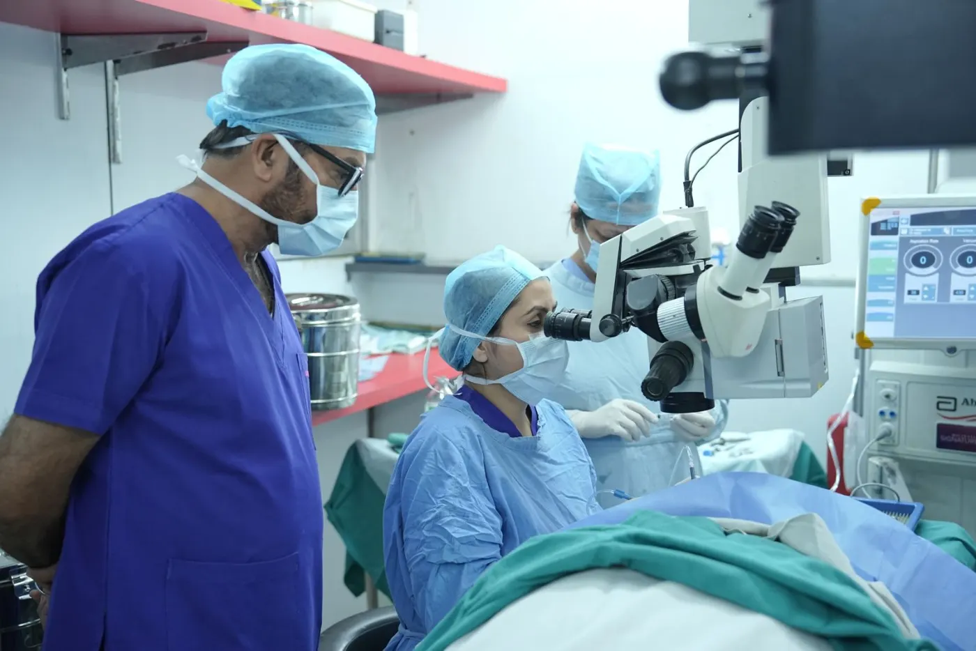 An eye surgeon operating under a surgical microscope in an operating theatre