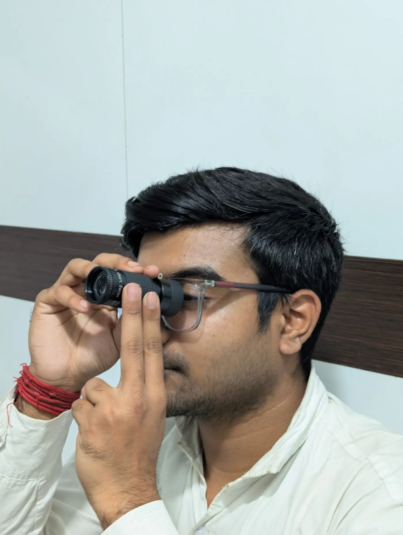 An older man reading a vision chart at an eye clinic